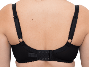 Back side view of model wearing black BM Balconette bra zooming in on the clasp and showing the design of the straps on the back